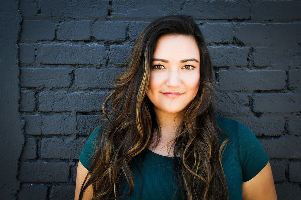 Woman has experienced all her symptoms being rectified and is positively certain about her longevity and wellbeing, standing in front of brick wall.