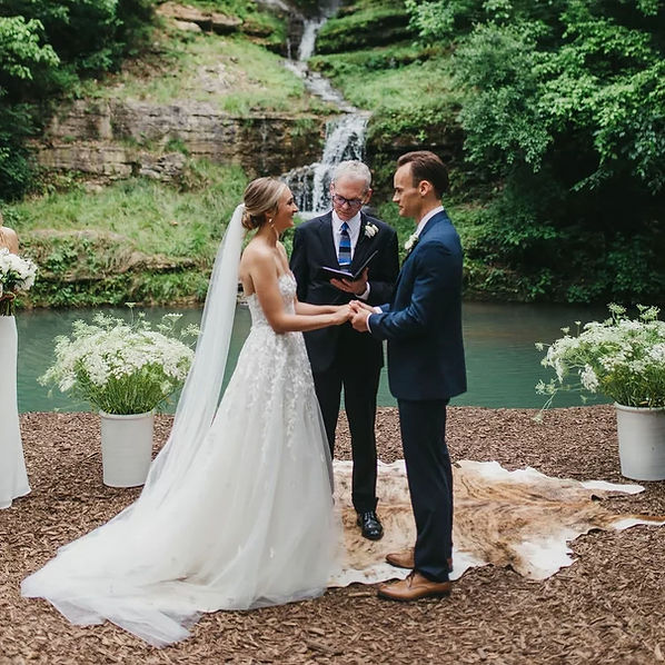 couple exchanging wedding vows in front of waterfall