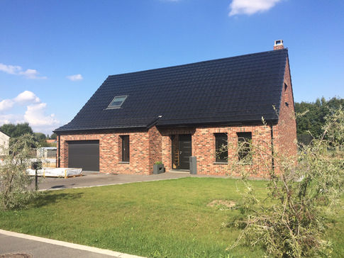Villa individuelle avec toiture en pente douce et terrasse aménagée, construction sur mesure par Maison & Villa, constructeur maison Lens