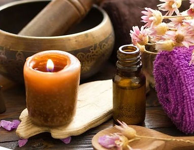 Ambiance d'un massage tantrique avec bougie, huile et gong.