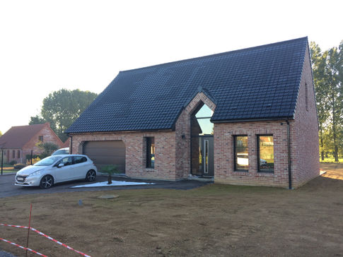 Villa traditionnelle avec façade en briques et jardin arboré, constructeur maison Béthune par Maison & Villa.