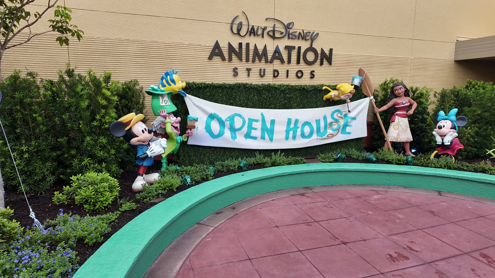 Character figures hold an Open House banner outside The Magic of Disney Animation at Disney's Hollywood Studios