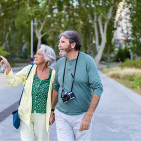 Happy retired couple living overseas and walking along the beach