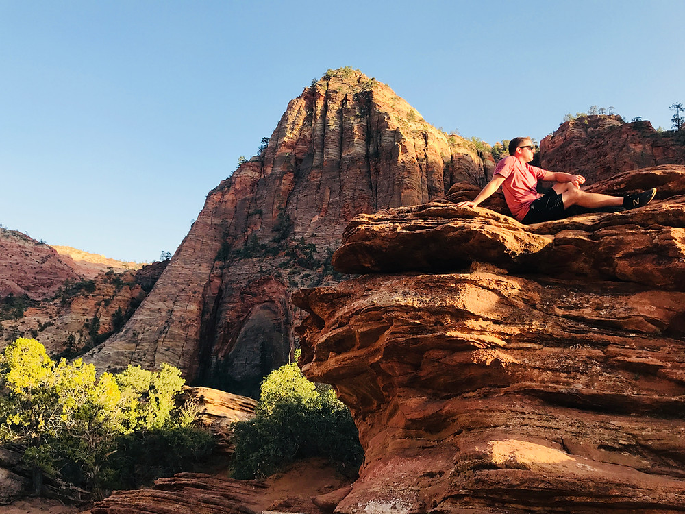 Man sitting peacefully on a mountain at Zion