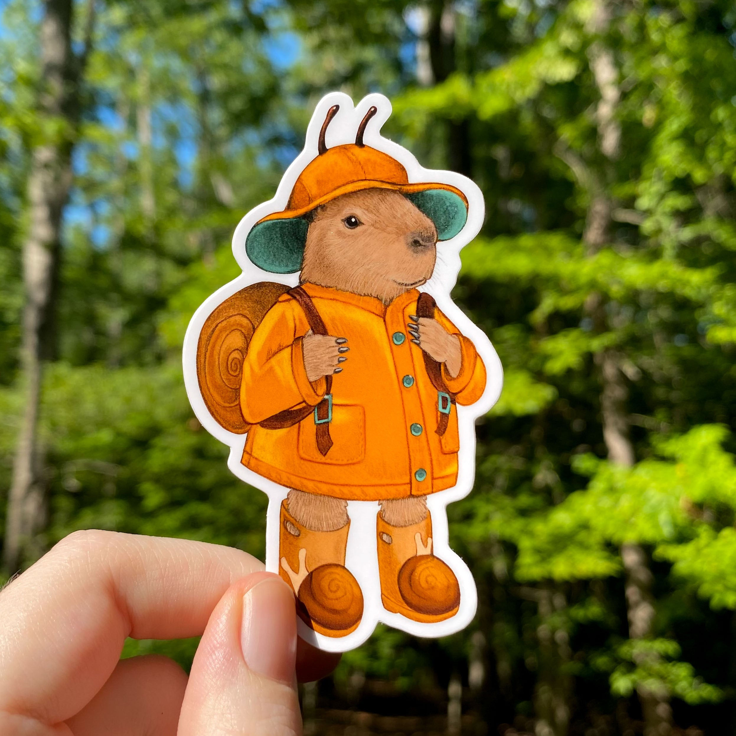 A sticker of a capybara in an orange raincoat.
