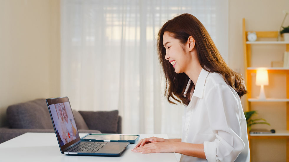 Seorang perempuan muda menggunakan laptopnya untuk melakukan video call dengan orang tua
