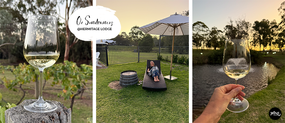 Wine glass on a post in a vineyard, person relaxing on a lounge chair under an umbrella, sunset view with wine glass, text: Oz Sundowners @Hermitage Lodge.