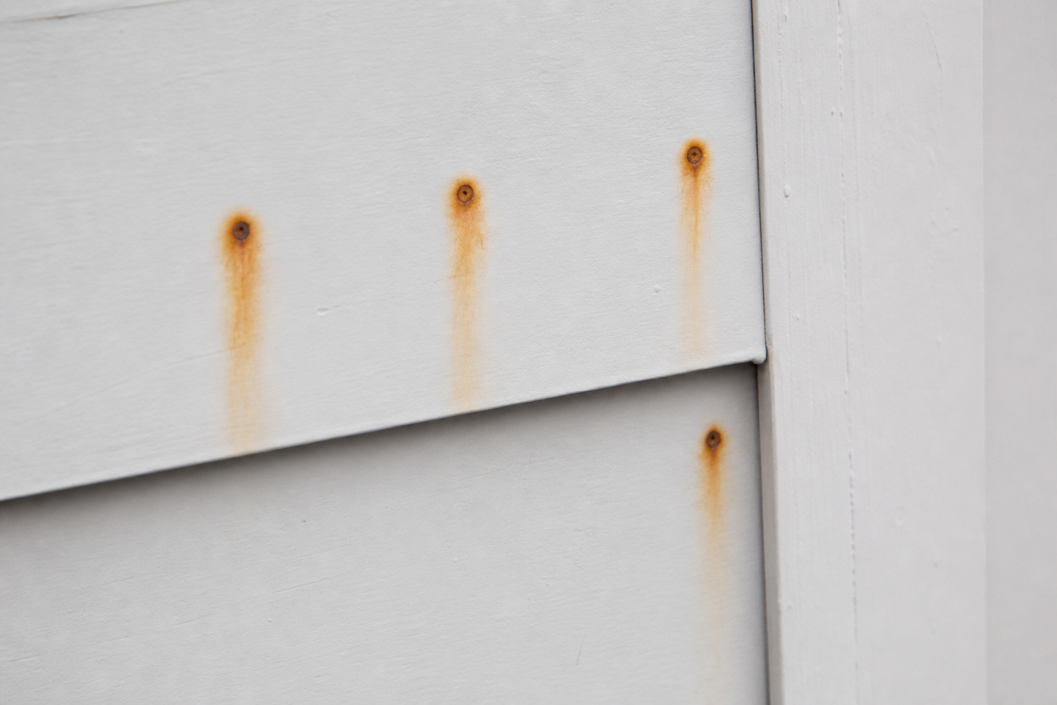 Why are rust spots appearing over nail heads?