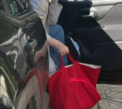 mulher saindo do carro com bolsa cotuê