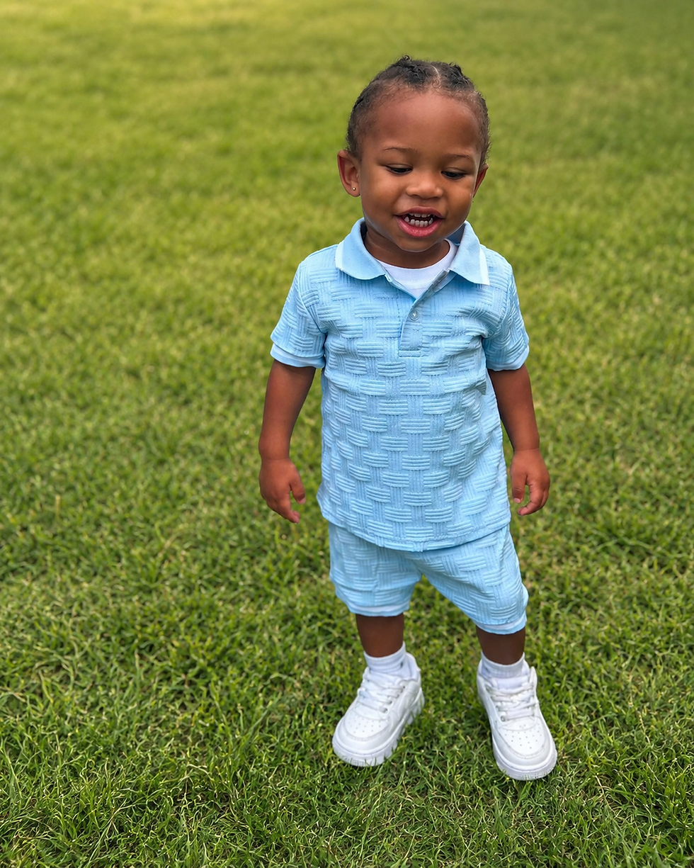 A JLS Little Legends toddler model in a light blue polo set.