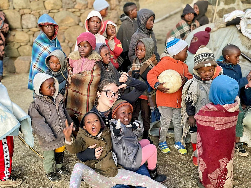 Jeunes filles avec des enfants africains pendant la visite d'un orphelinat en afrique du sud