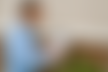 pest inspector in a light blue shirt completing an NPMA 33 wood destroying insect report on a clipboard while inspecting the stucco and brick foundation of a Hudson Florida home