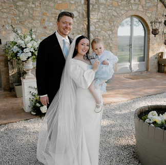 Bride, groom, and family celebrating together in group shot at Conti di San Bonifacio Tuscany, luxury romantic Italian destination wedding