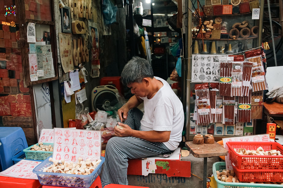 artisan-pham-ngoc-toan-crafting-wooden-stamps-on-hang-quat-street-hanoi-old-quarter