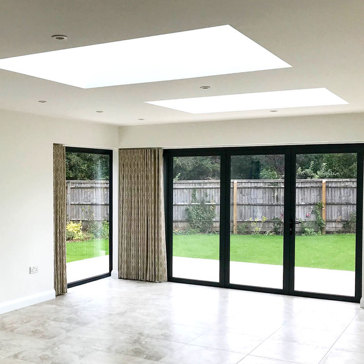 Open plan kitchen with skylights and doors onto garden