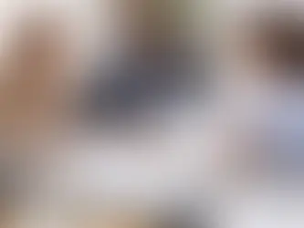 Three colleagues discuss paperwork at a table. A clipboard reads "COMPLIANCE" with a checklist. Mood is collaborative and professional.