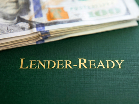 A close-up view of US hundred-dollar bills resting on a forest-green textured background, featuring the gold serif text "Lender-Ready" below the currency, ideal for a financial services blog cover.