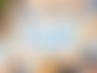 A team analyzes charts and graphs labeled "BENCHMARKING" on tablets and paper, surrounded by office supplies on a wooden table.