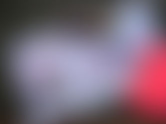 A top-down view of a dark desktop featuring a "Revenue report" bar graph, a smartphone displaying a calculator app, a magnifying glass, colored pencils, and a red spiral notebook, illustrating the process of analyzing business income and financial data.