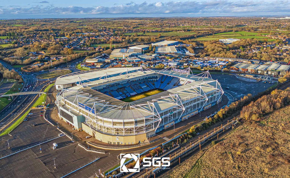 Sweeping aerial drone photograph of the Coventry Building Society Arena and surrounding area.
