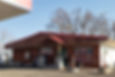 A building with a red roof and wood siding is pictured.