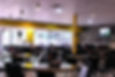 The interior of Vaquero's shows bright yellow walls with wooden accent walls and big windows in front. There is plenty of seating and a television on one wall.