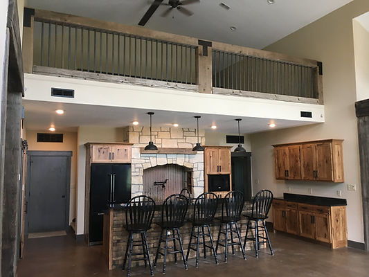 A beautifully remodeled kitchen is shown, complete with custom stone fireplace sink-facade and island.
