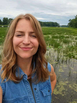 Ashley smiling joyfully in front of the Mississippi River