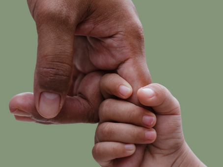 child's hand grasping the finger of their mother