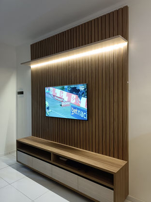 Home planejado para sala, feito em madeira, com painel ripado e iluminação LED, exibindo TV fixada na parede. O design moderno aproveita bem o espaço e traz sofisticação ao ambiente.