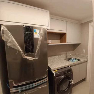 Lavanderia planejada com armários sob medida e bancada funcional, otimizando o espaço de serviço.