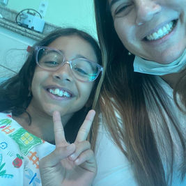 Dra. Teresa Longo com paciente criança sorrindo na Clínica Teresa Longo