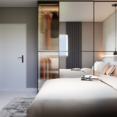 Quarto suíte de apartamento no Fit One, com armário planejado, cama de casal e televisão embutida na parede.