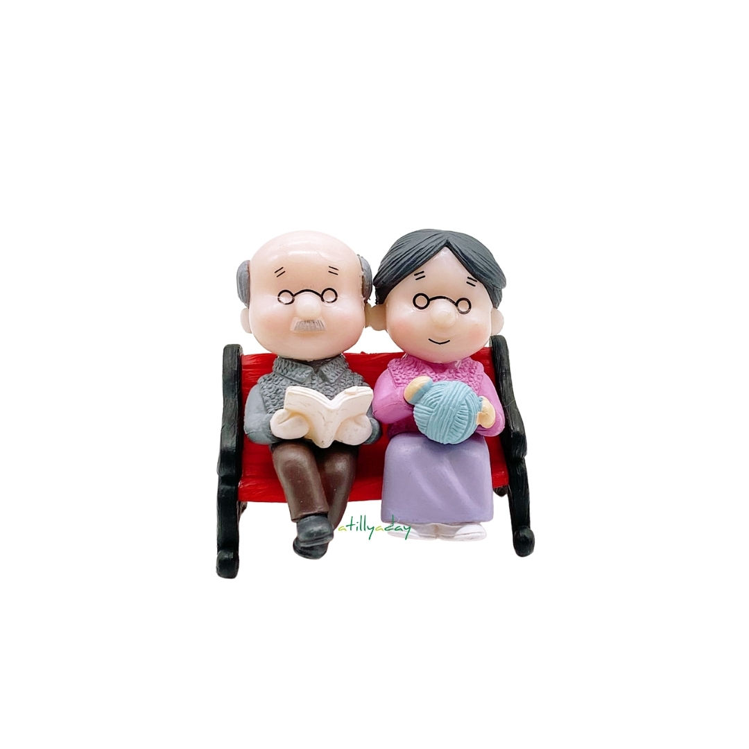 Grandfather reading a book and grandmother weaving figurine