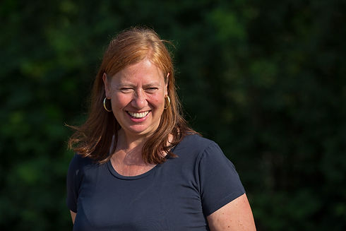 Katja Hammerschmidt lächelt, Portrait vor dunklem HIntergrund