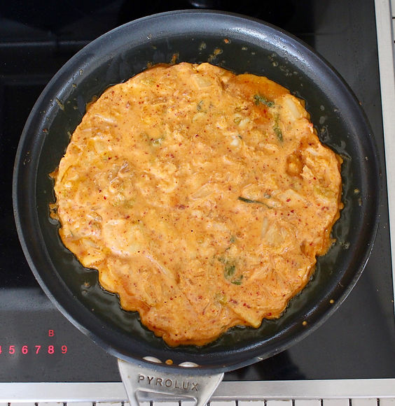 kimchi pancake cookig in a frying pan