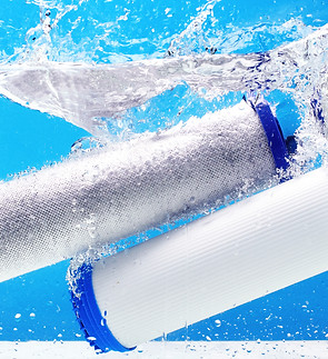 New carbon filter cartridge for house water filtration system isolated on blue background.