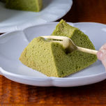 緑色の抹茶シフォンをフォークで割る様子