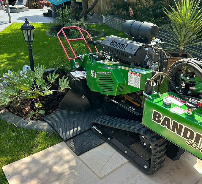 Preparing for tree stump grinding in Brentwood with protective mats to protect the garden