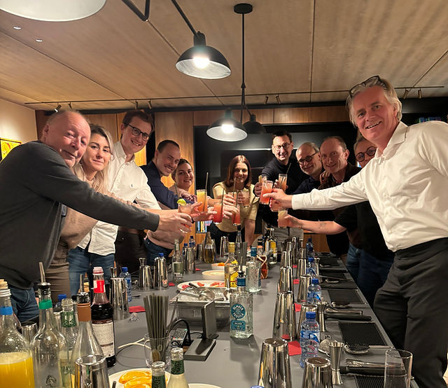 Participants gathered around a fully prepared cocktail workshop table during a mixology class.