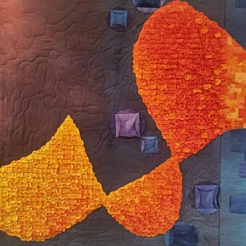 An example of stitched texture and hand dyed colour on a piece of fibre art in a gallery