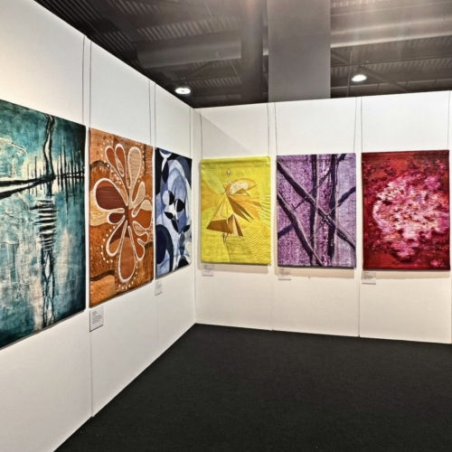 Six examples of colour and texture in fibre art in a gallery