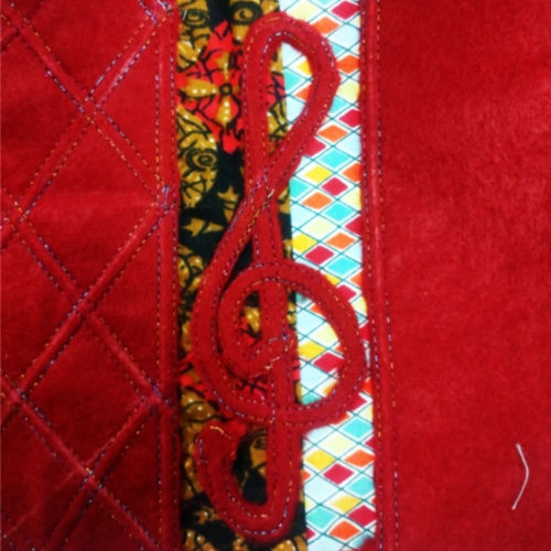 Patchwork of fabric with a decorative layer stitched on top. An example of work in progress at the Reverse Appliqye & Twin Needle Workshop