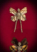 Two framed mummified fairies with insect wings on red velvet background.