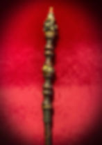 Handmade ornate wooden wand with details on red velvet.