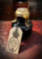 Mystical dark bottle with dripping gold wax, "SPEAK TO THE DEAD" tag.