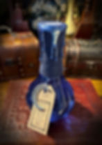 Dark blue glass bottle, waxed string neck, "ELIXIR" tag, moon charm.