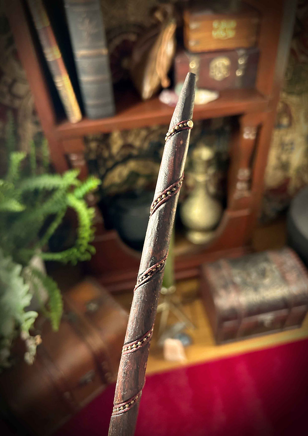 Thumbnail: Handmade dark wand, spiraling brass inlay, against antique shelf.