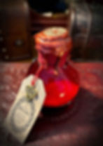 Small red bottle "Potion of Healing" with wax seal and decorative tag.