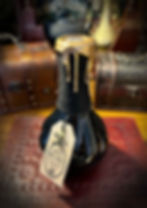 Black bottle, gold wax, "WITCH'S BLOOD" tag, antique background.
